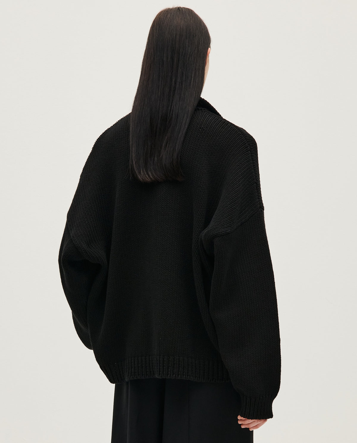 Black Babaà Polo No1 shirt worn by a woman, featuring a classic collar and short sleeves, styled casually.