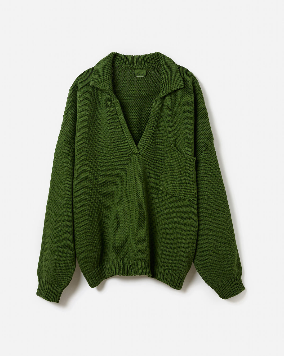 Silhouette of a woman wearing Babaà Polo No1 Pine, a stylish green polo shirt, showing the classic collar and short sleeves.