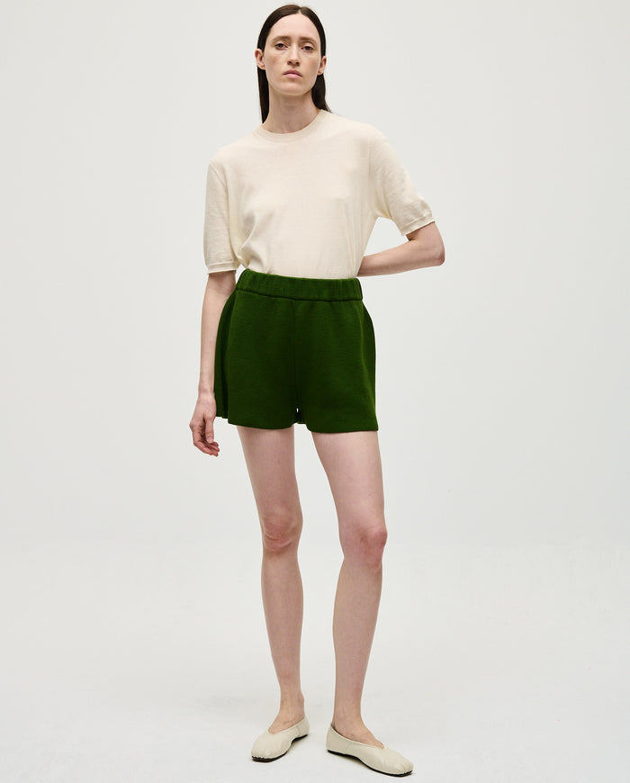Babaà No35 Pine shorts worn by a woman, featuring a relaxed fit and pine green color, suitable for casual summer wear.