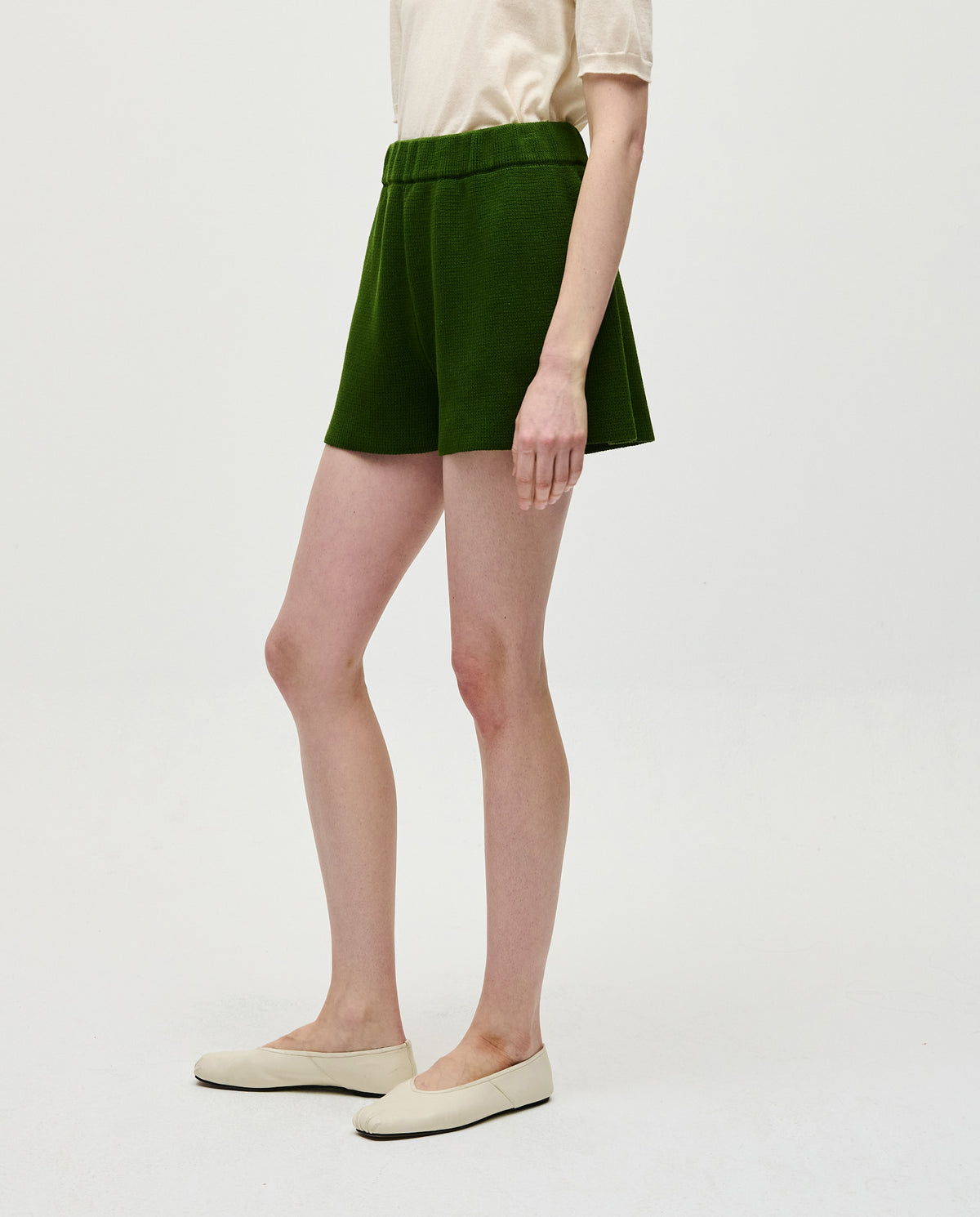Woman wearing Babaà No35 Pine shorts, lightweight casual shorts in pine green with a relaxed fit, suitable for summer wear.