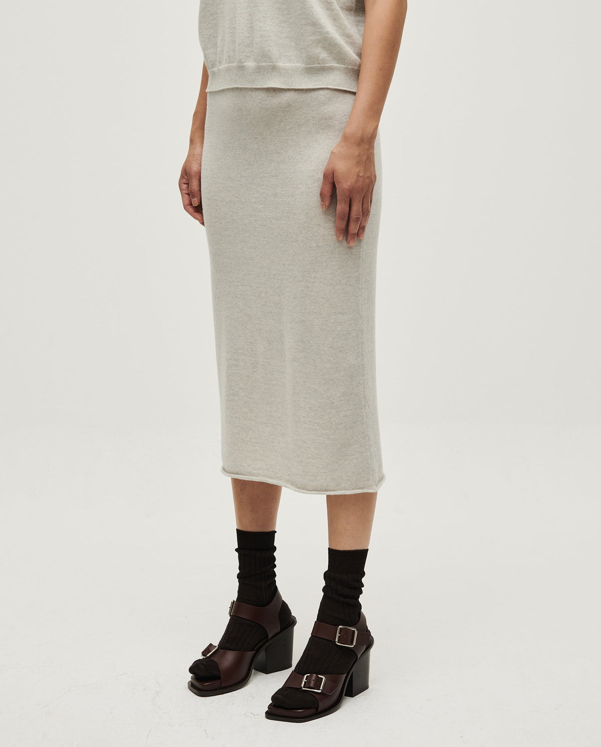 Woman wearing Babaà Skirt No25 Estrella with floral pattern and flowing fabric, styled for a casual or dressy look.
