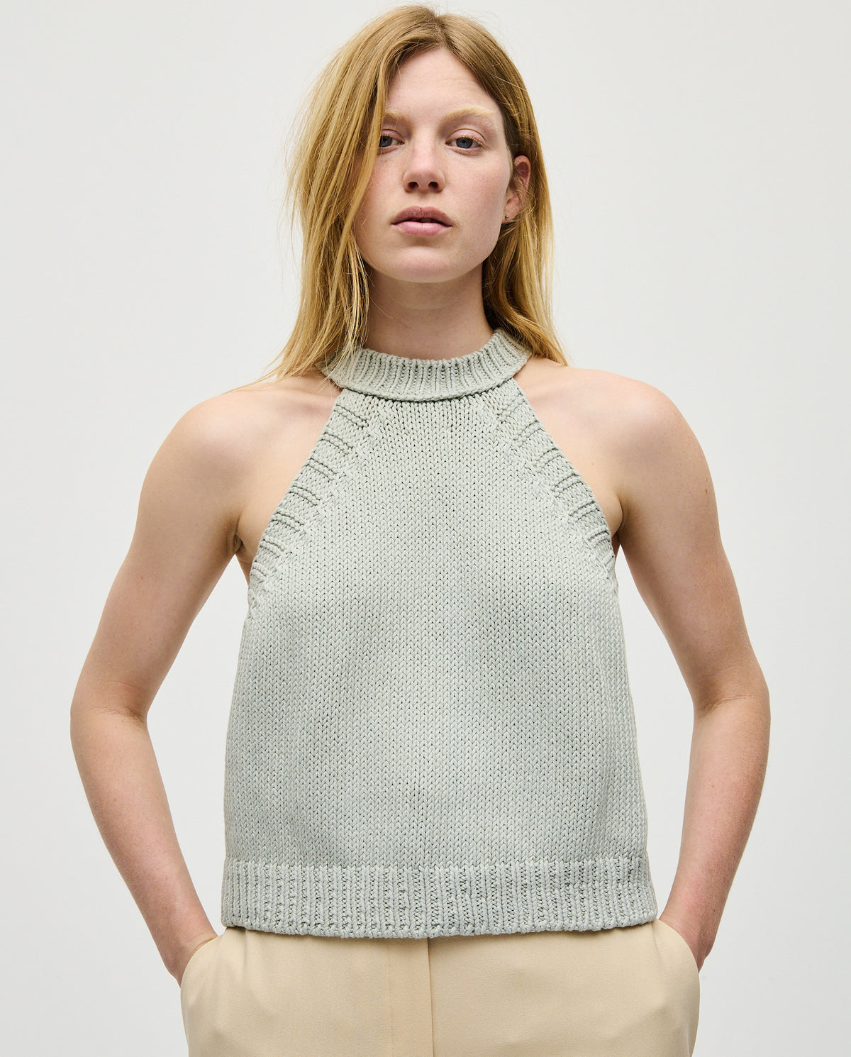 Woman wearing Babaà Top No2 Chalk, stylish sleeveless top with a fitted design, showcased in a fashion image.