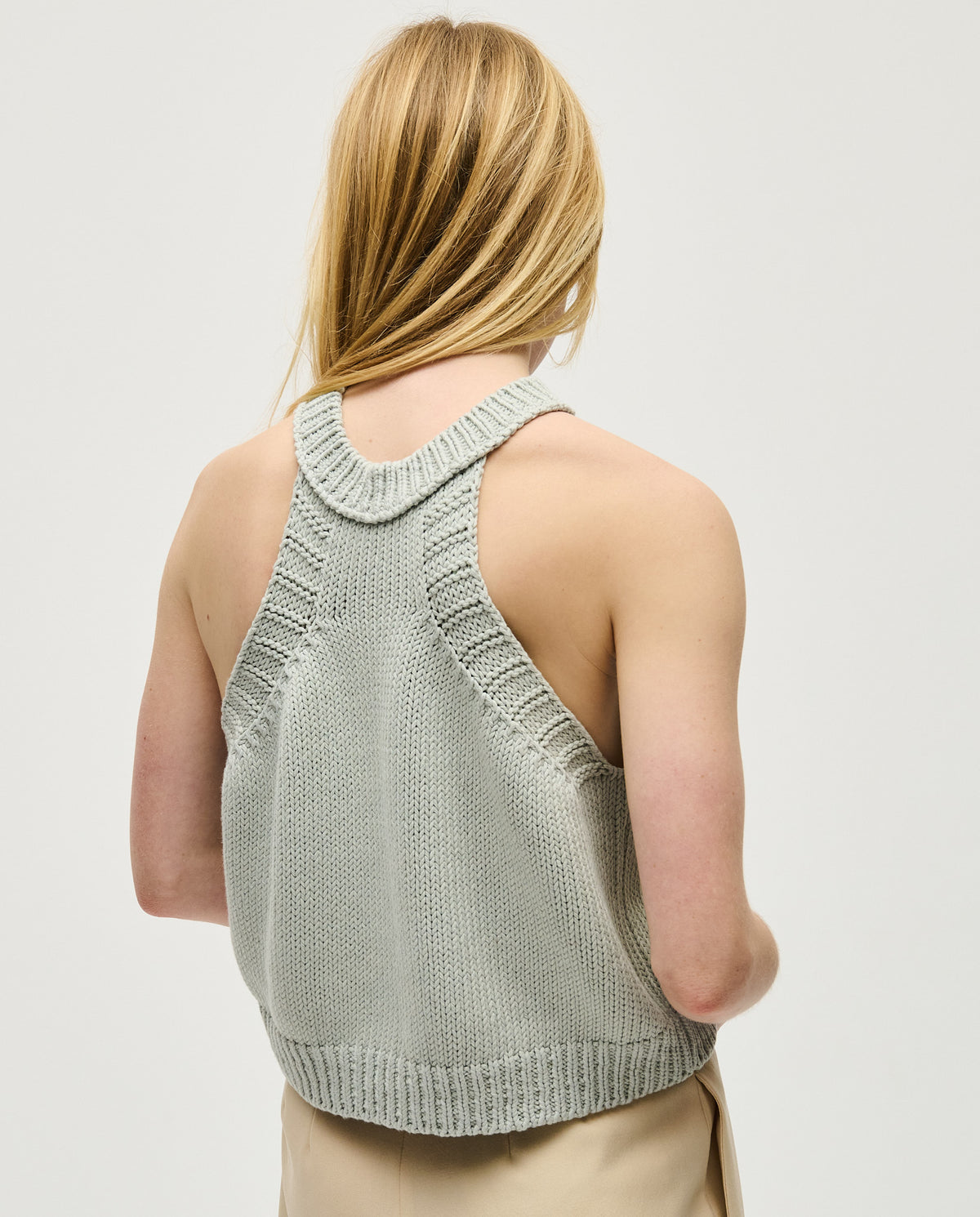 Woman wearing Babaà Top No2 Chalk athletic top, showcasing breathable fabric and stylish fit for active wear.