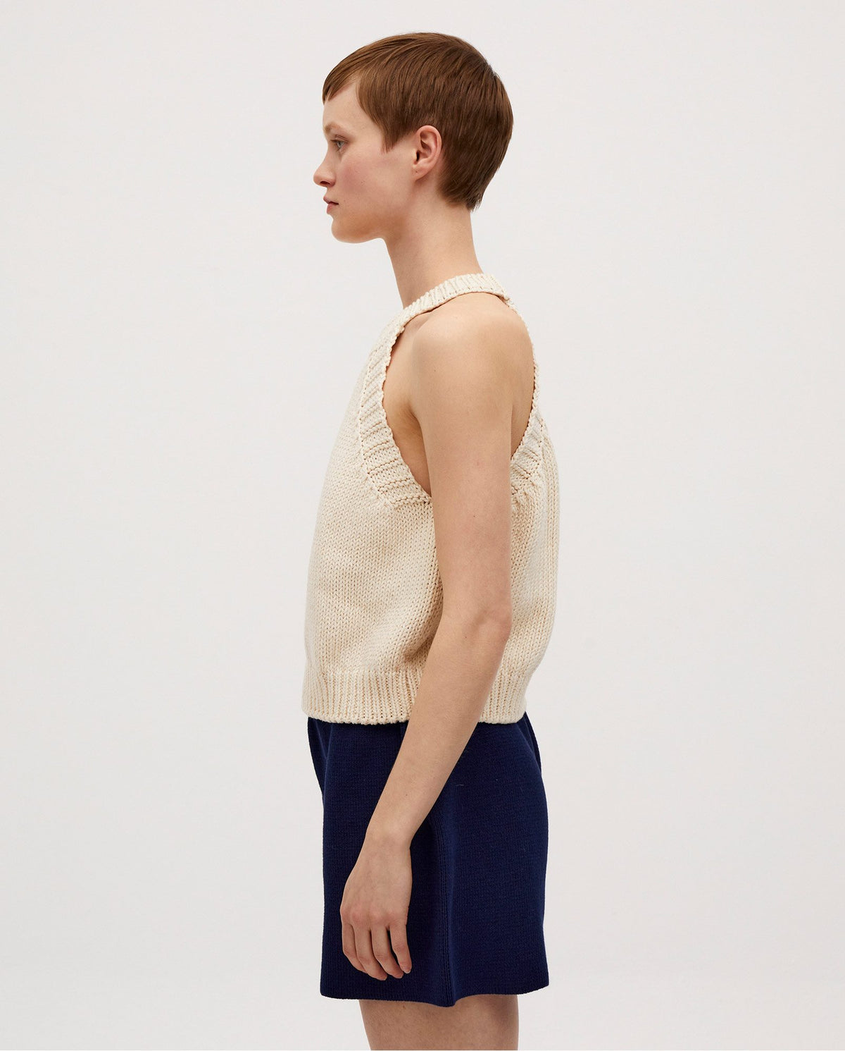 Woman wearing the Babaà Top No2 Natural, a stylish sleeveless top with a relaxed fit, shown in a natural fabric.
