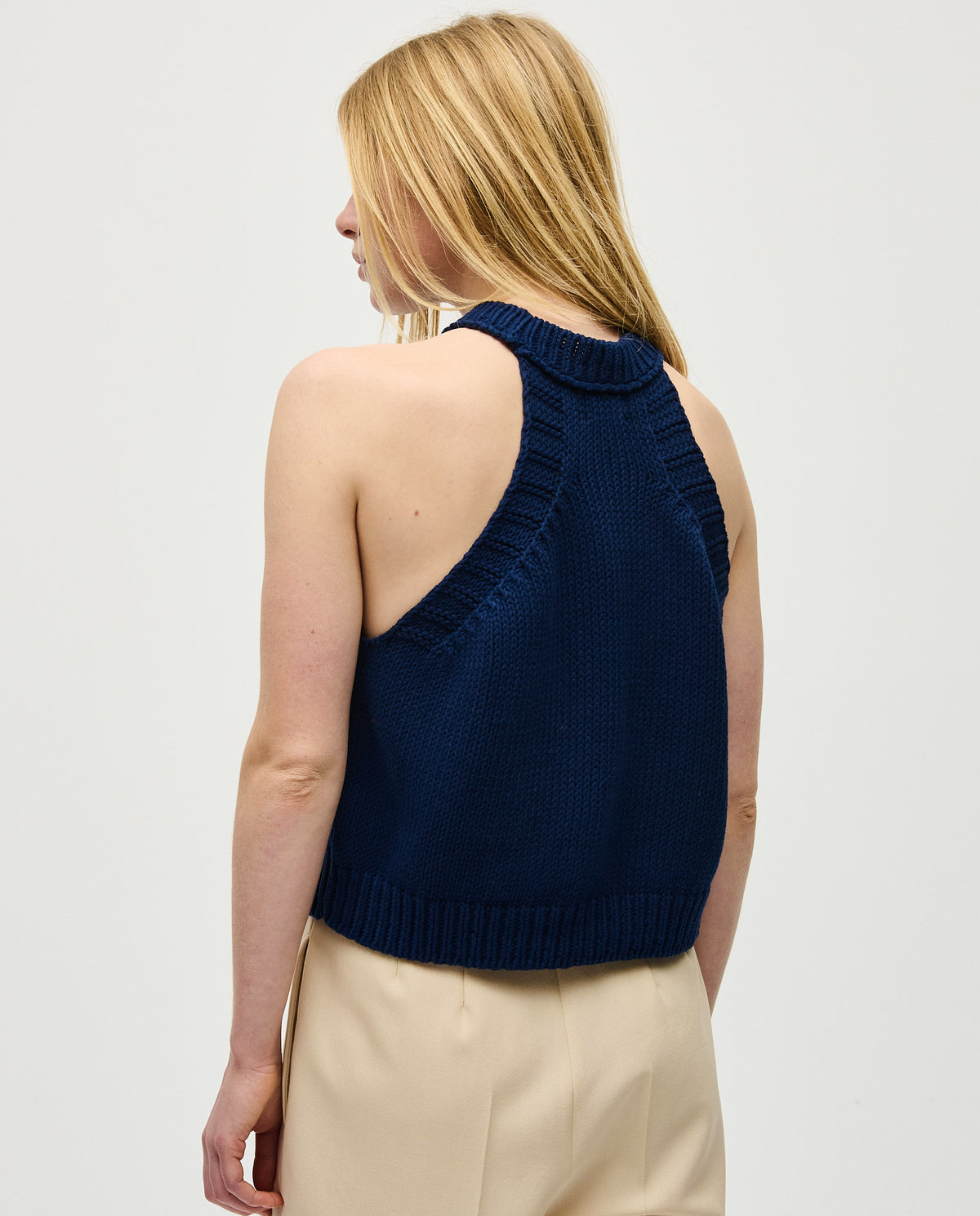 Navy Top No2 by Babaà worn by a woman, showcasing a stylish sleeveless design with a high neckline and smooth fabric.