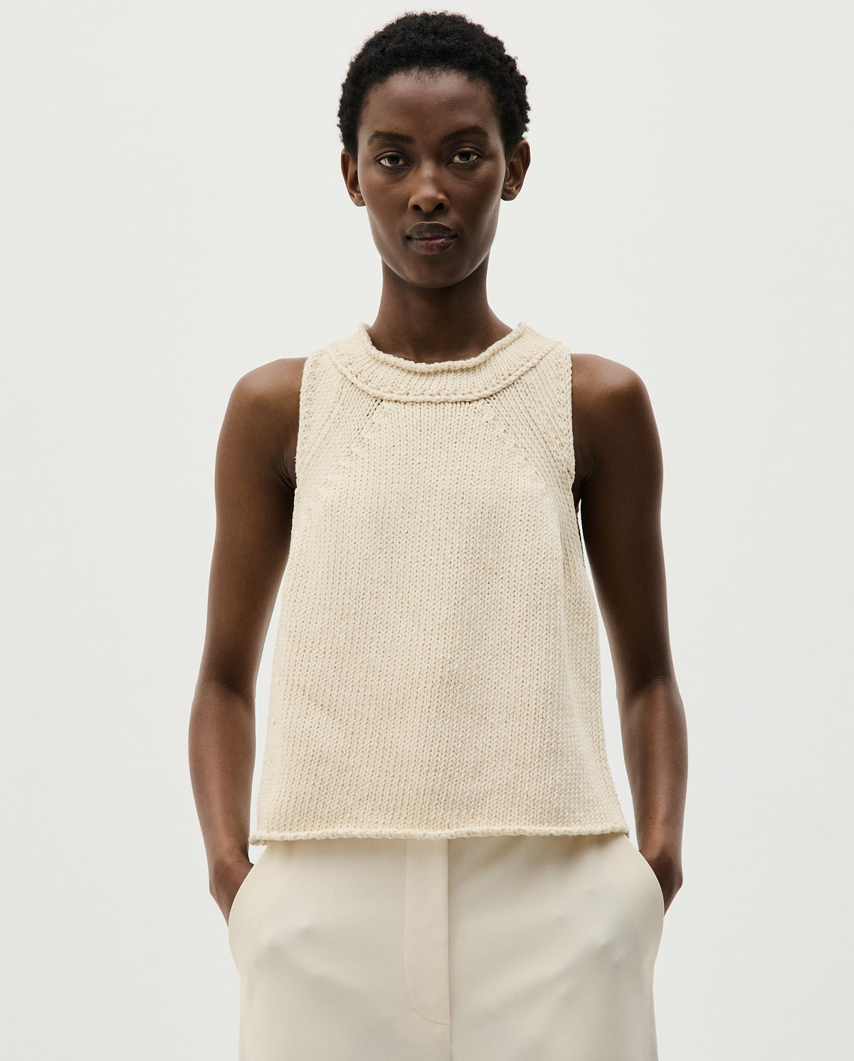 Woman wearing Babaà Top No46 Natural, showcasing a stylish, natural-colored sleeveless blouse with a relaxed fit.