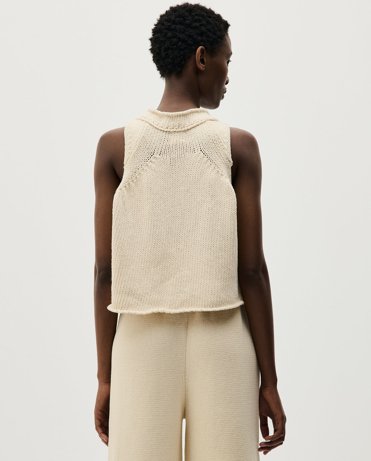 Woman wearing Babaà Top No46 Natural, showcasing a stylish, natural-colored sleeveless top with a relaxed fit.