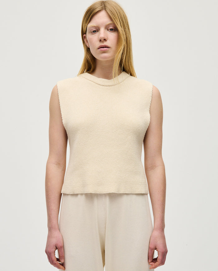 Woman wearing Babaà Top No85 Natural, a stylish and comfortable sleeveless top in a natural fabric with a relaxed fit.