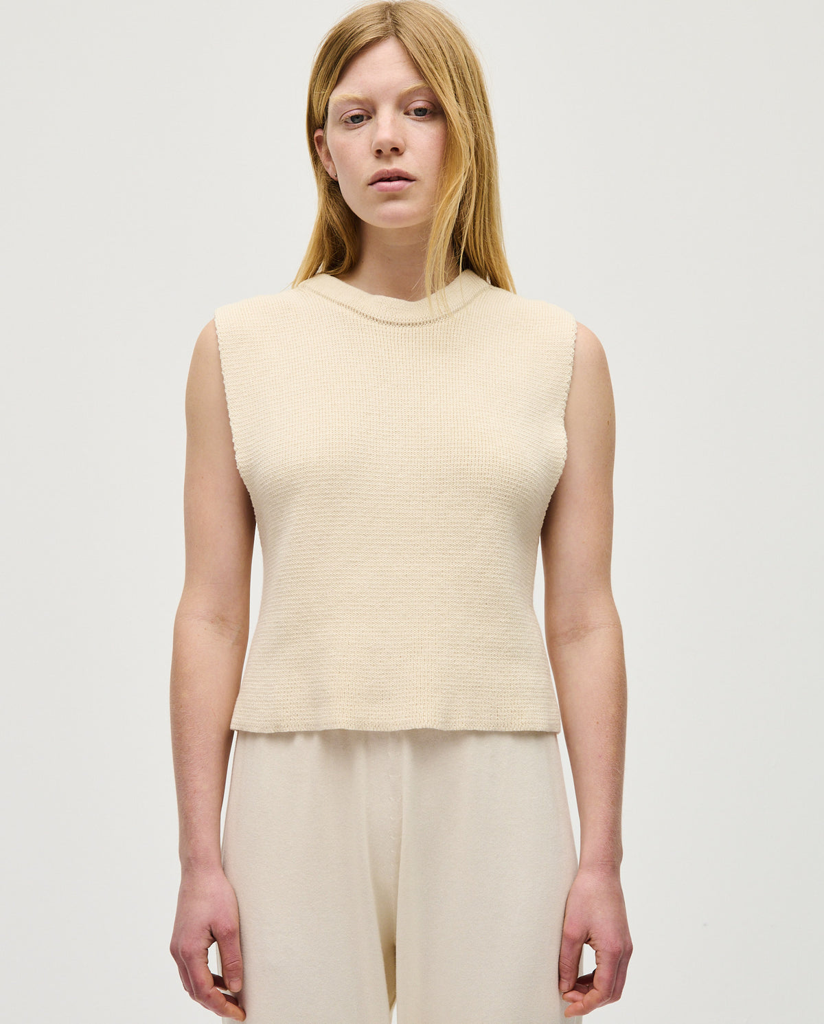 Woman wearing Babaà Top No85 Natural, a stylish and comfortable sleeveless top in a natural fabric with a relaxed fit.