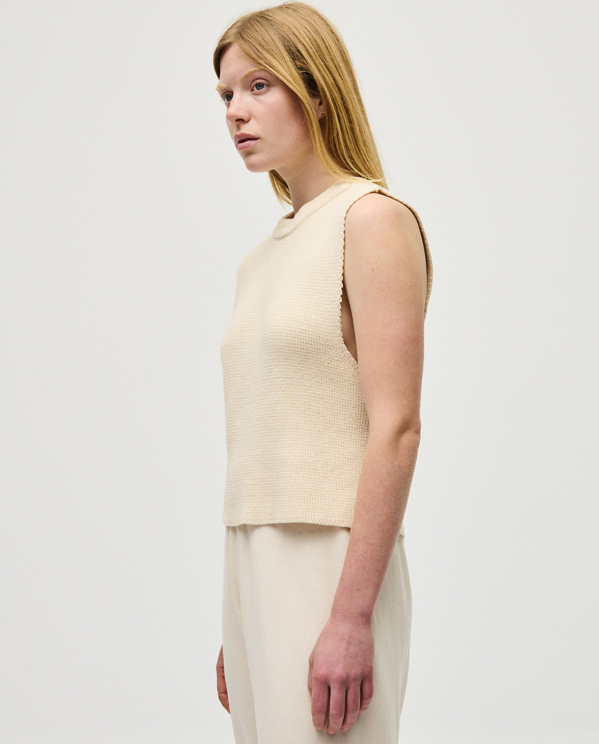 Woman wearing Babaà Top No85 Natural, stylish sleeveless blouse with a relaxed fit and natural fabric appearance.