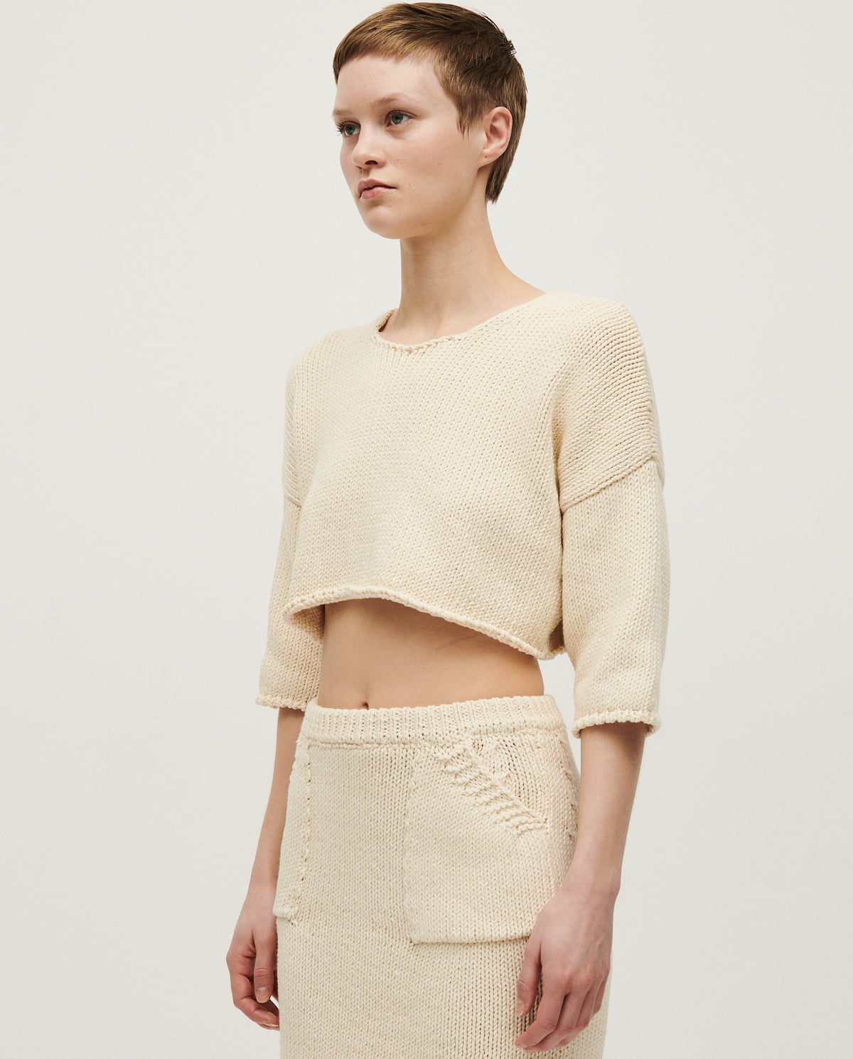 Woman wearing Babaà Top No9 Natural, a stylish and comfortable sleeveless top in a natural fabric, shown on a model.