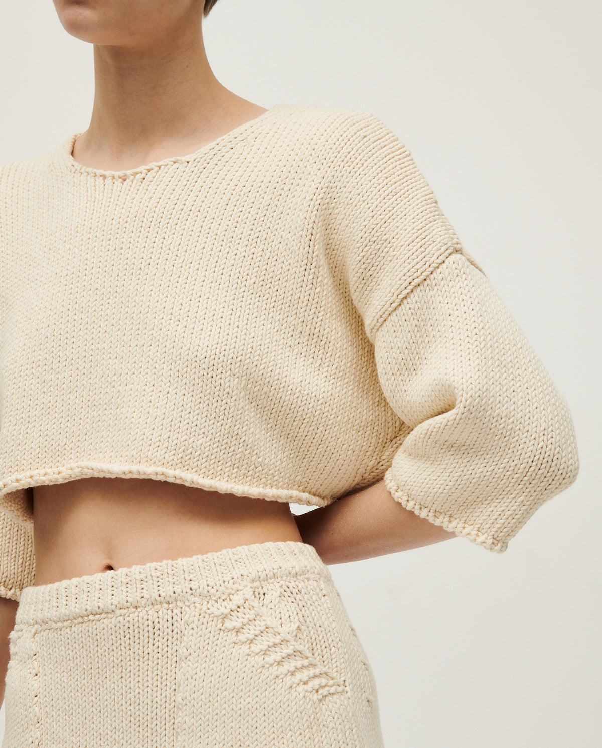 Woman wearing Babaà Top No9 Natural, a stylish sleeveless top made from sustainable fabric, shown on a model.