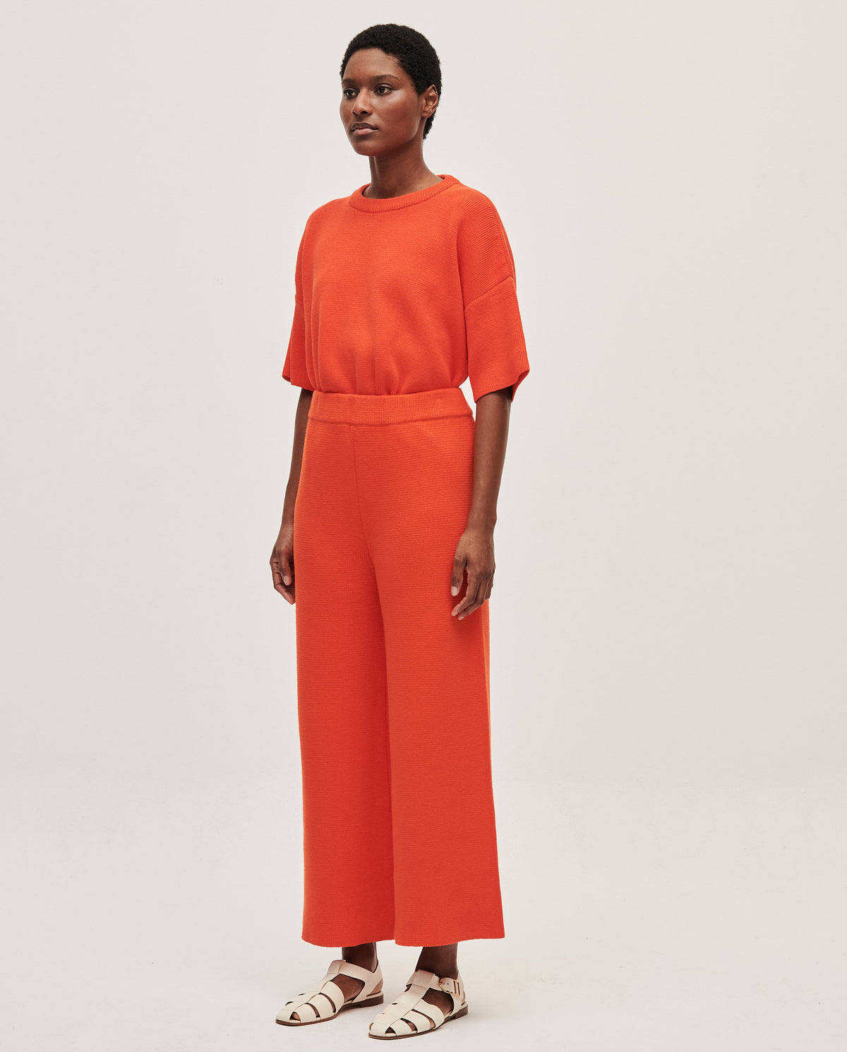 Babaà No35 Tangelo women's trousers with a relaxed fit and vibrant orange color, shown on a model in a casual setting.