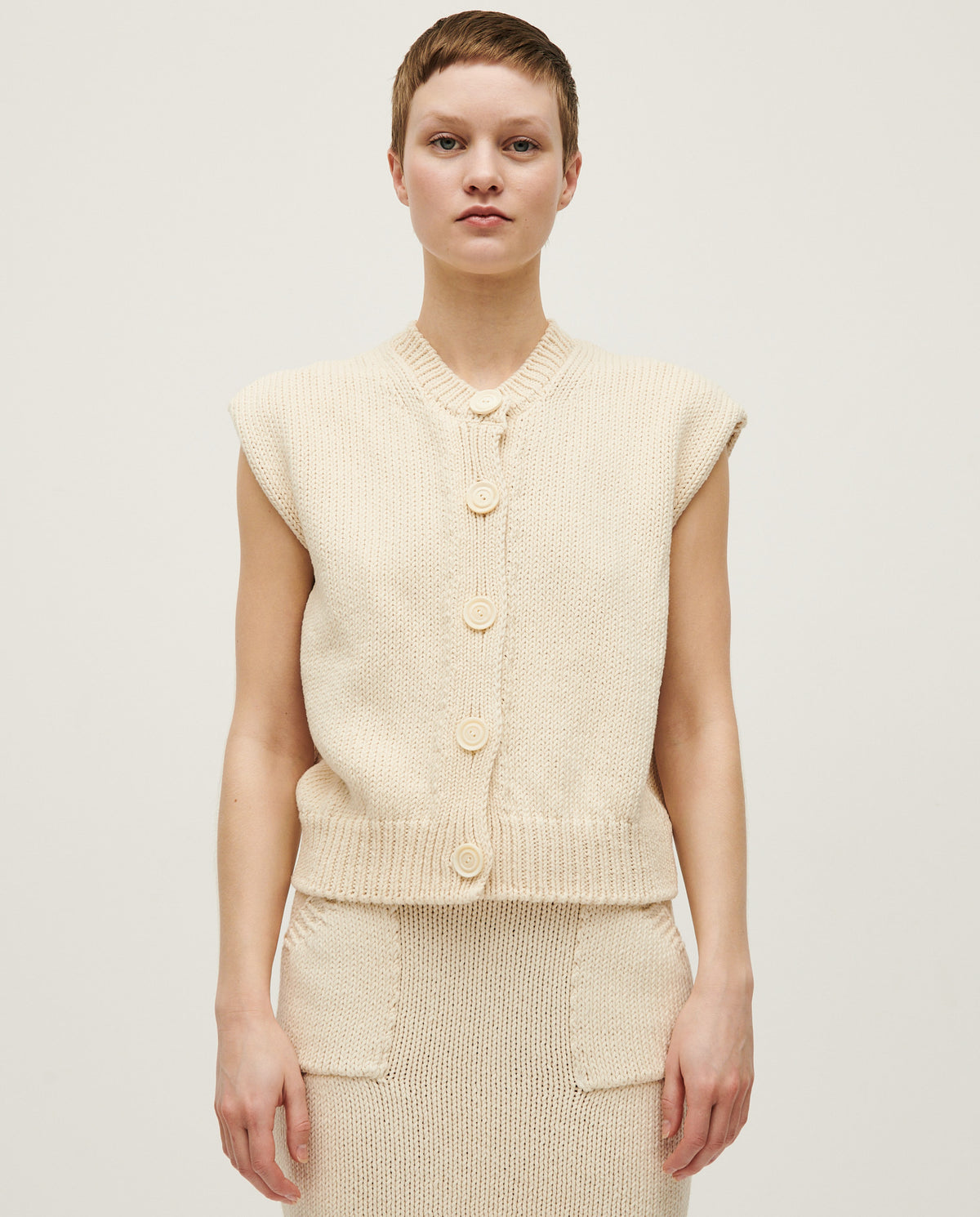 Woman wearing Babaà No26 Natural vest, showcasing the soft, natural fabric and relaxed fit of this stylish sleeveless top.
