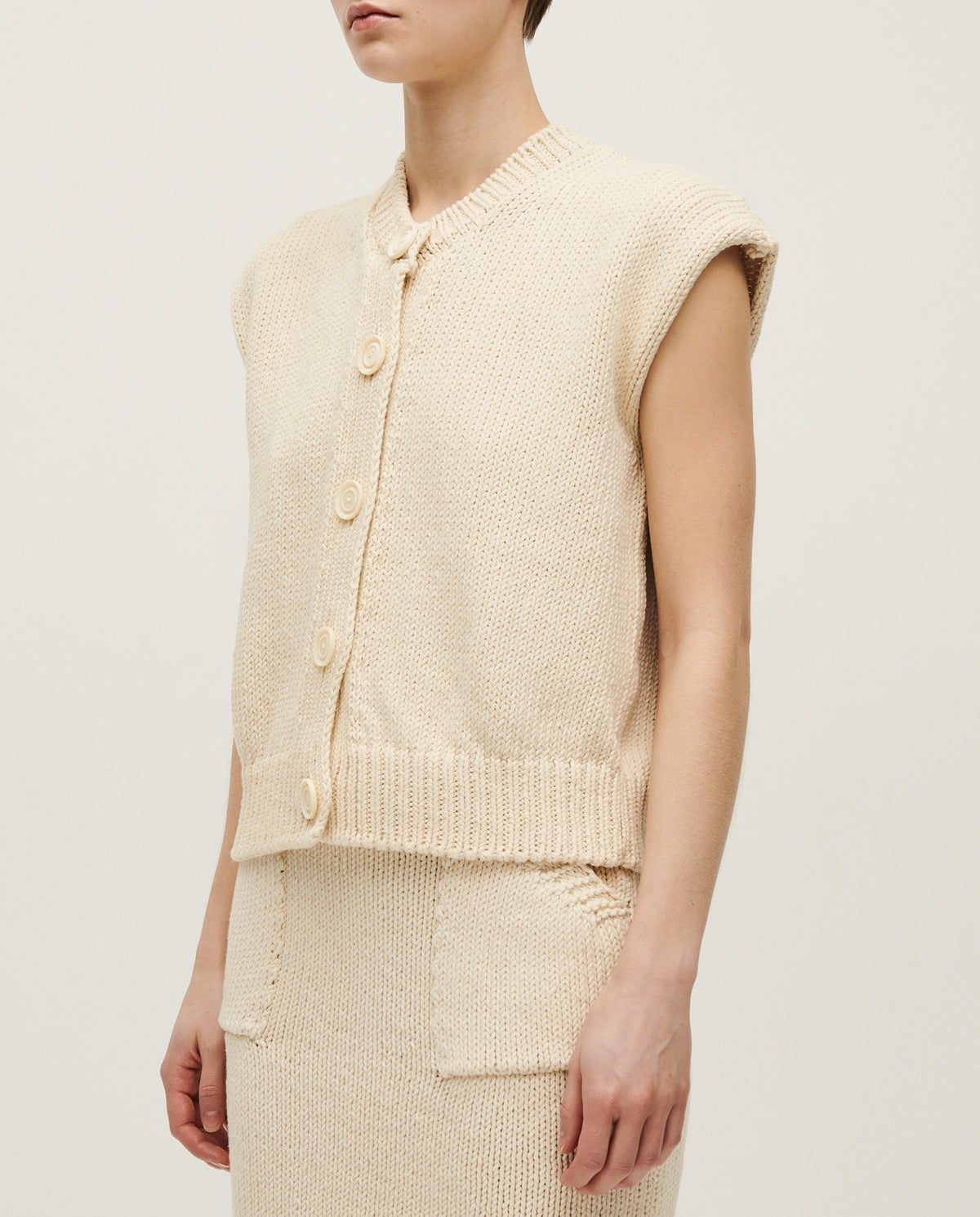 Woman wearing Babaà No26 Natural vest made of soft, breathable fabric, showcasing a relaxed fit and natural color.
