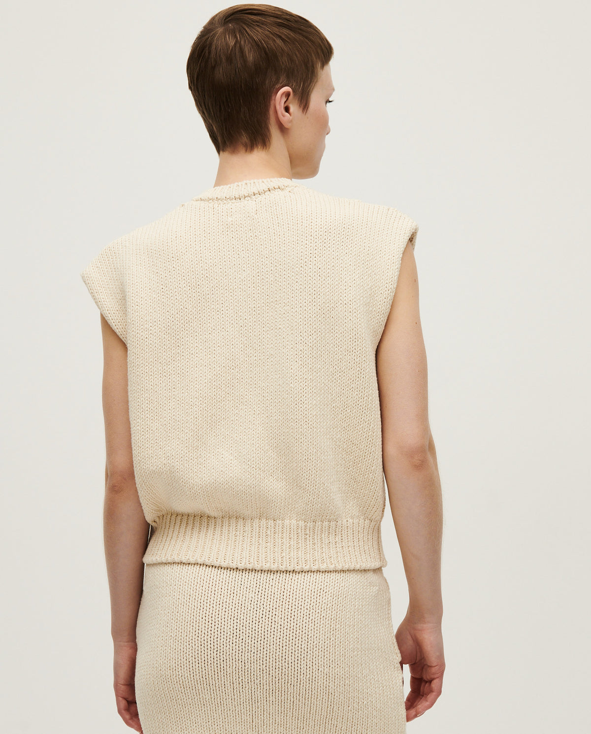 Woman wearing Babaà No26 Natural vest made of soft, organic fabric, showcasing a relaxed fit and neutral earthy tone.