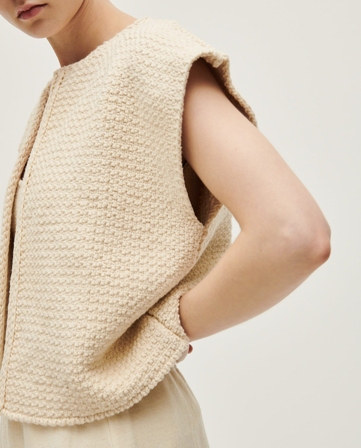 Woman wearing Babaà No8 Natural vest, soft sleeveless top with a relaxed fit, in light natural fabric.