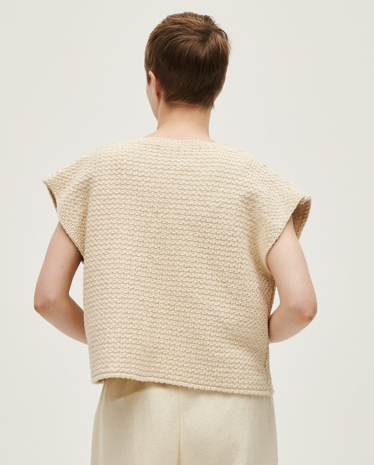 Woman wearing Babaà No8 Natural vest, a soft, sleeveless knit top with a relaxed fit and natural beige color.